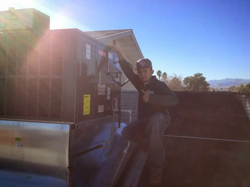HVAC technician performing HVAC Inspection on a rooftop unit in Jackson
